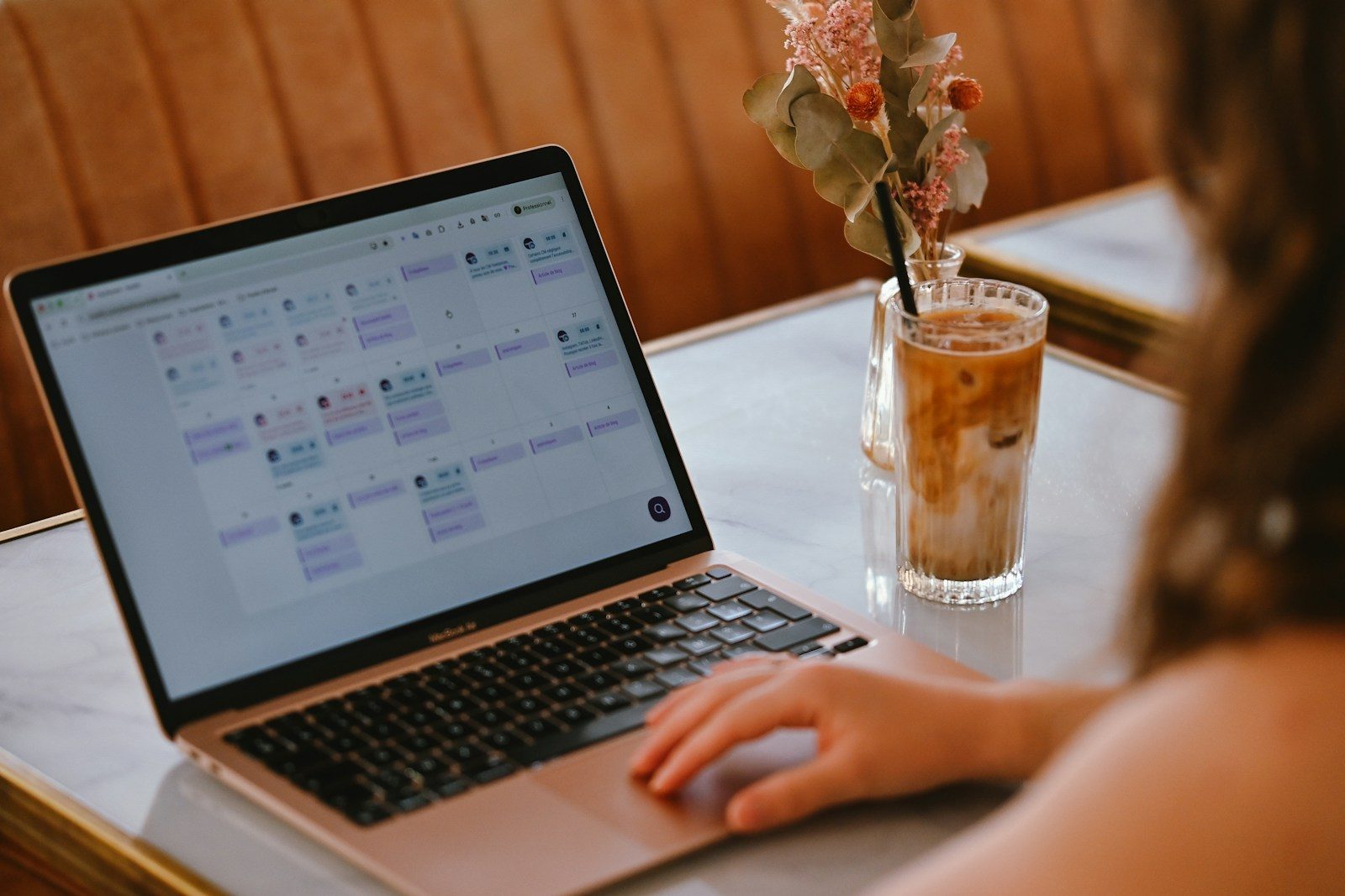 Person planning tasks on a laptop with AI-powered scheduling software