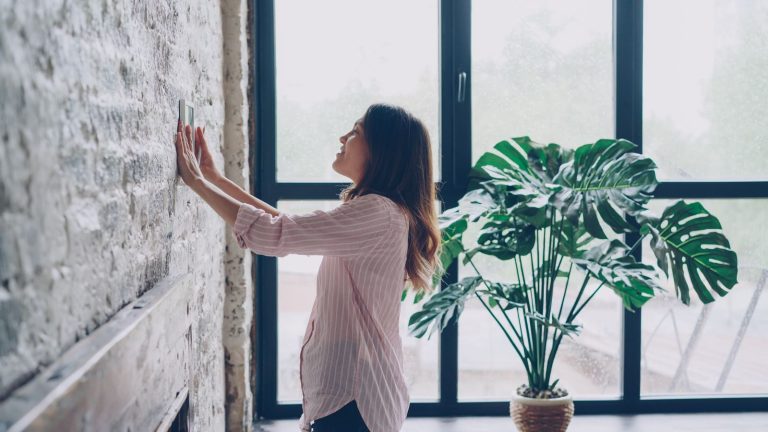 Best smart thermostat for home mounted on a living room wall.