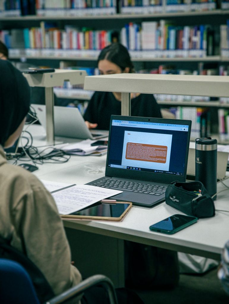 Students studying with some of the best laptops for students in a modern library